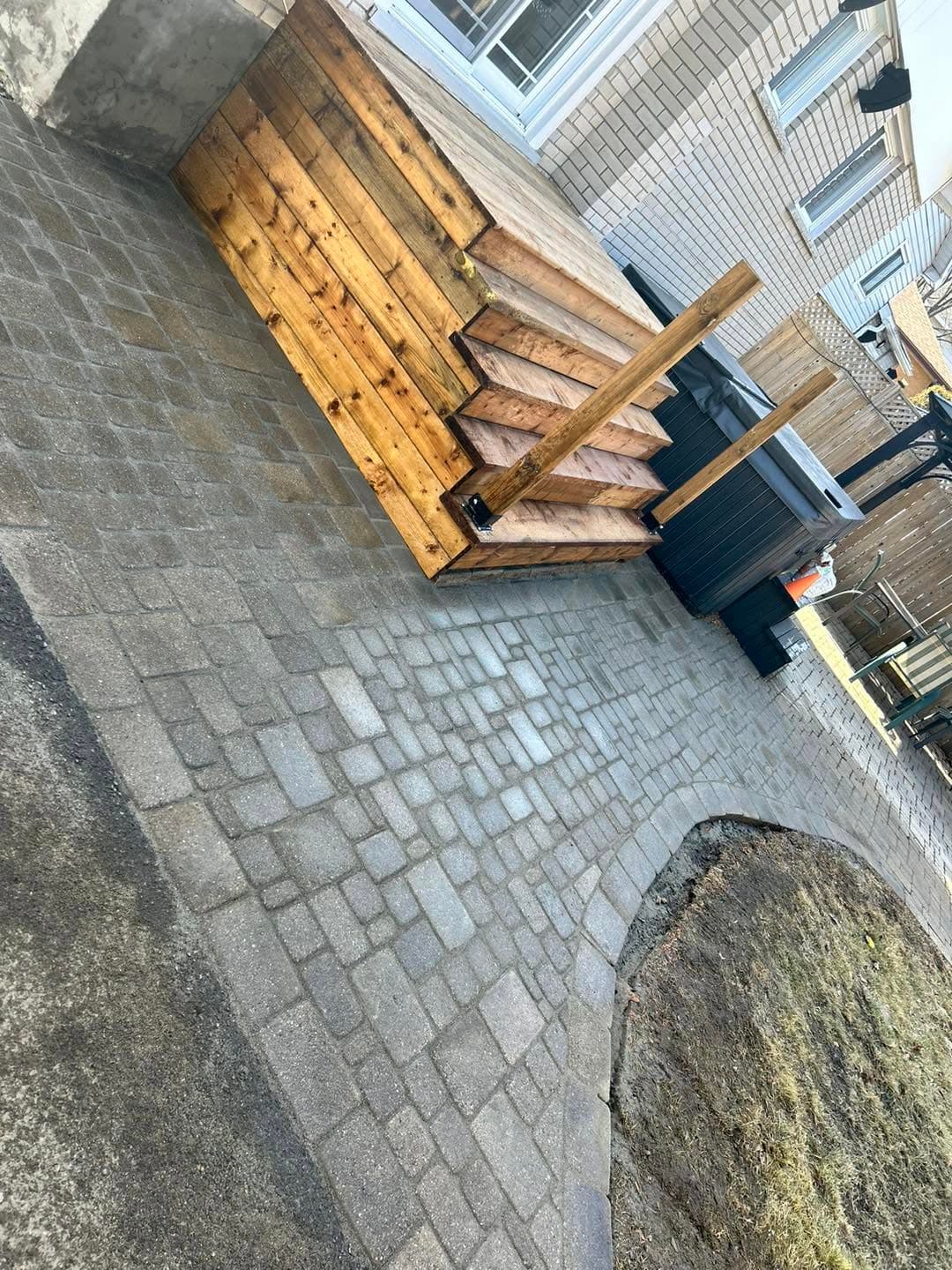 Interlock paver walkway wrapping around a natural stone boulder