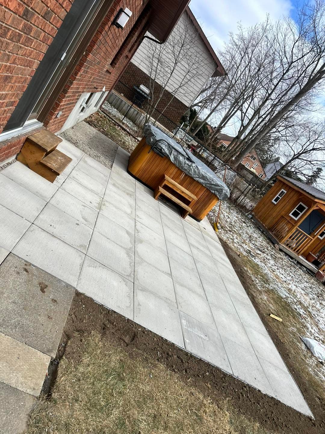 Large-format slab patio installed behind a brick home