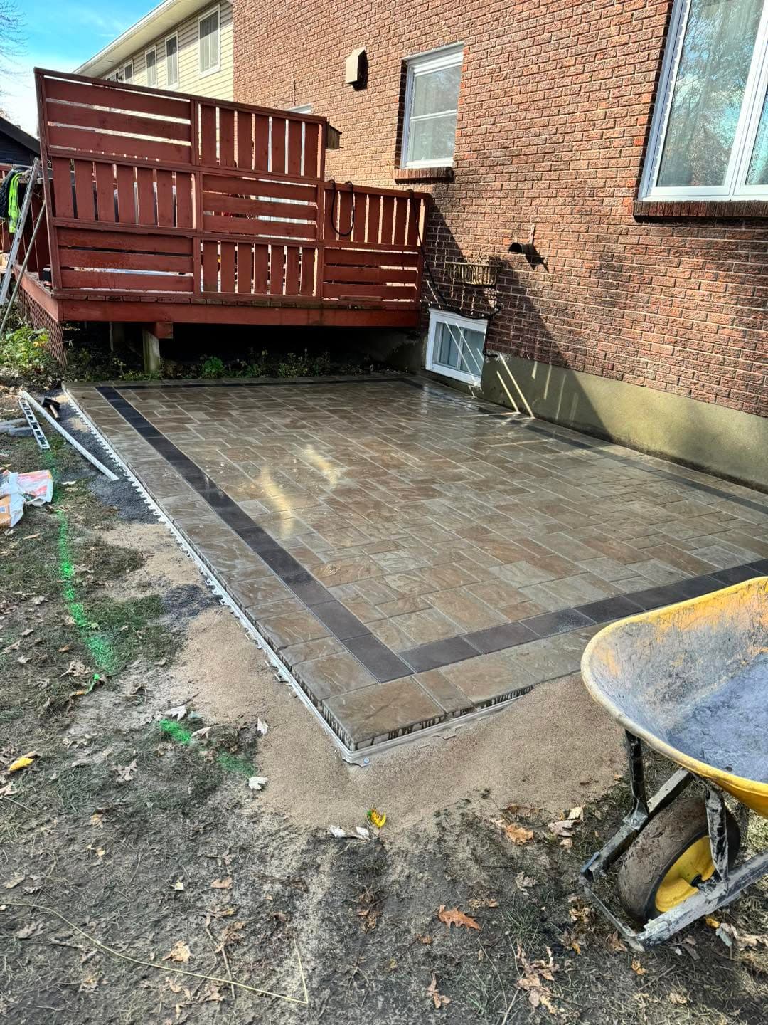 Interlock patio with contrasting border installed beneath a wood deck
